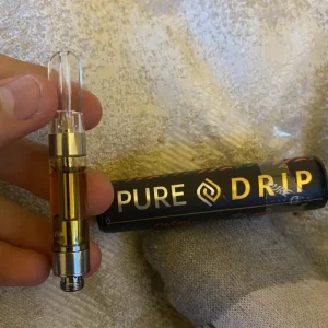 Hand holding a Pure Drip 1G cannabis cartridge, highlighting its sleek design and high-quality cannabis extract for a smooth vaping experience.